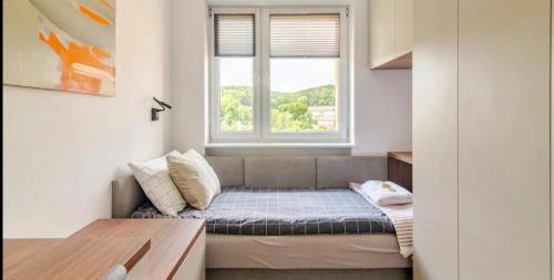 ein kleines Zimmer mit einem Sofa und einem Fenster in der Unterkunft Oliwa luxury apartment, free parking, high speed internet in Danzig