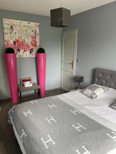 - une chambre avec un lit recouvert de vases roses dans l'établissement Écrin de verdure, à La Tour-de-Salvagny