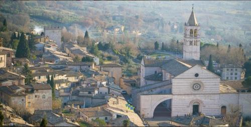 a small town with a church and a tower at Hotel Roma Assisi in Assisi