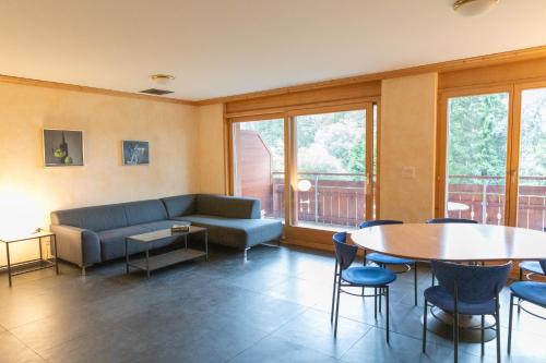 a living room with a couch and a table and chairs at Résidence Grenon in Crans-Montana