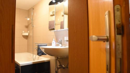 a bathroom with a sink and a bath tub and a sink at FERIENWOHNUNG "Belle Helene" in Wangle