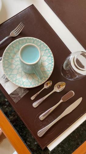 a table with a plate and cutlery on a tray at Pousada Vida feliz in Águas de Lindóia