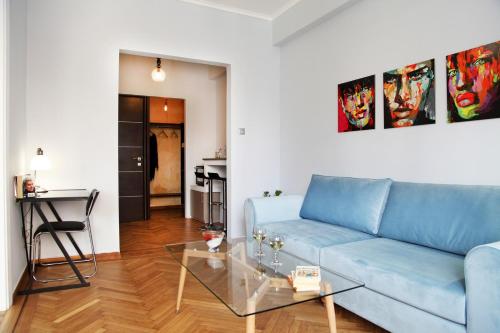 a living room with a blue couch and a glass table at My Athens House in Athens