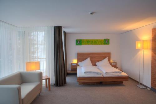 une chambre d'hôtel avec un lit et un canapé dans l'établissement Pepis Skihotel, à Sankt Anton am Arlberg