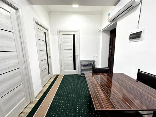 a conference room with a wooden table and two doors at Apartment ART HOUSE in Khiva