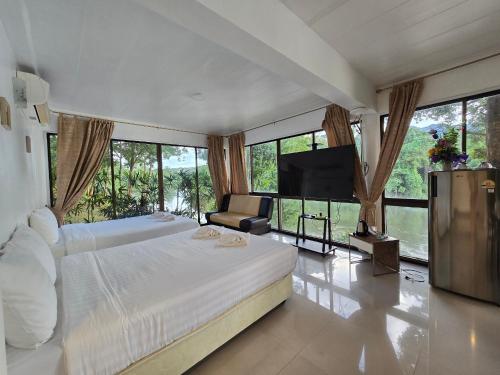 a bedroom with a large bed and a flat screen tv at Puprai Tarnnarm Resort in Thong Pha Phum
