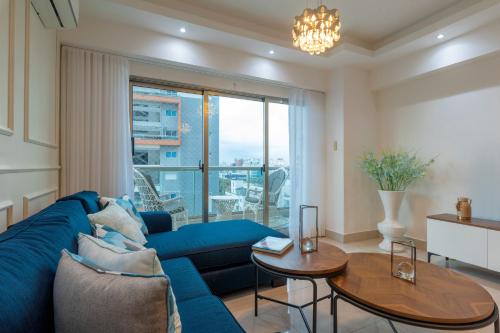 a living room with a blue couch and a table at Escape Apartments, Balcony, Pool, Gym & Spa in La Julia in Santo Domingo