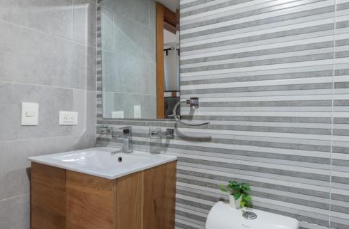 a bathroom with a sink and a mirror at Escape Apartments, Balcony, Pool, Gym & Spa in La Julia in Santo Domingo