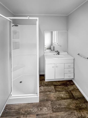 a white bathroom with a sink and a mirror at Onehunga Oasis l 2bed Private Home l Cornwall Park in Auckland