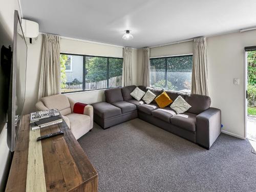a living room with a couch and a table at Onehunga Oasis l 2bed Private Home l Cornwall Park in Auckland