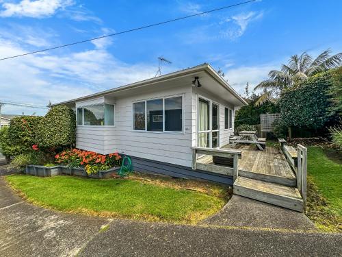 a small white house with a porch and a yard at Onehunga Oasis l 2bed Private Home l Cornwall Park in Auckland