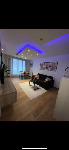 un salon avec des lumières bleues au plafond dans l'établissement Magnifique studio, à Dugny