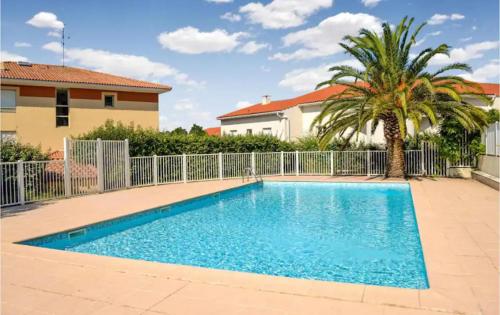 une piscine devant une maison avec un palmier dans l'établissement Studio climatisé avec piscine, à Saint-Raphaël