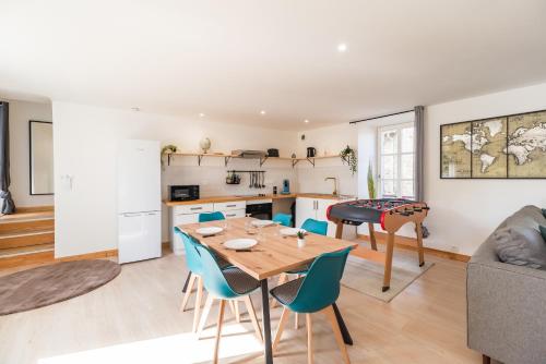 une cuisine et un salon avec une table et des chaises dans l'établissement Le Spacieux Baby foot 3 chambres Parking Centre, à Guingamp