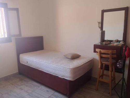 ダハブにある2 Bedroom Houseのベッドと机と椅子のある寝室