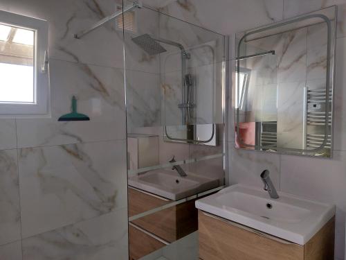 une salle de bain blanche avec un lavabo et une douche dans l'établissement Appartement Résidence Aphrodite Village naturiste à Port Leucate, à Leucate-Plage