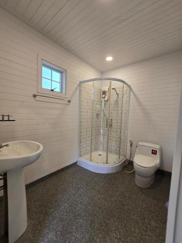 a bathroom with a shower and a toilet and a sink at Puprai Tarnnarm Resort in Thong Pha Phum