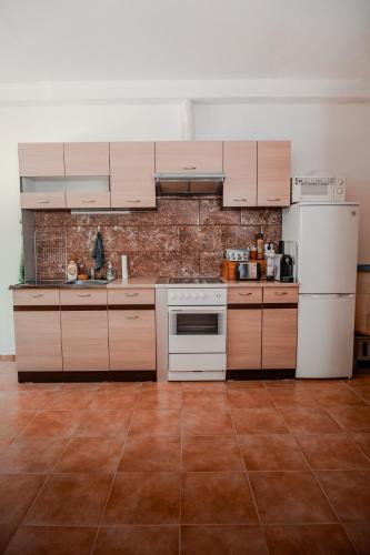 a kitchen with white appliances and a brick wall at Edi Birtok in Oroszló