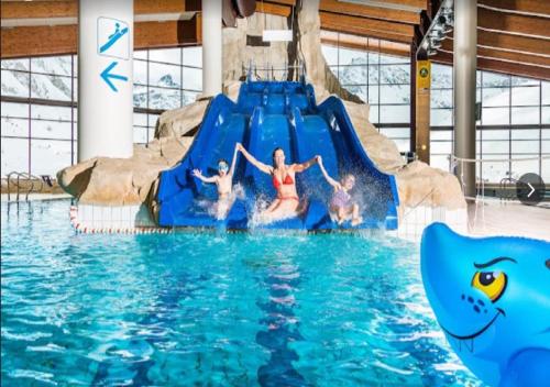 un groupe d'enfants sur un toboggan aquatique dans une piscine dans l'établissement Studio 20 Les Grandes Platières, à Tignes