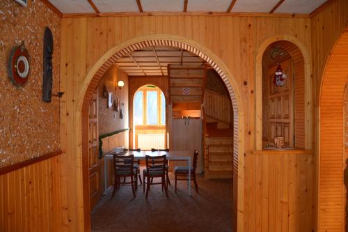 une salle à manger avec une arche dans une maison en bois dans l'établissement Sadyba Karpatiya, à Yaremtche