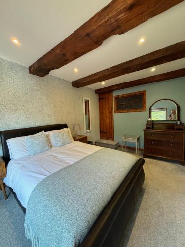 a bedroom with a large bed and a dresser at Cosy coastal hideaway with incredible sea views in Fortrose