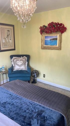 a bedroom with a blue bed and a chandelier at Cozy room near Airport & Highway in Saint Louis