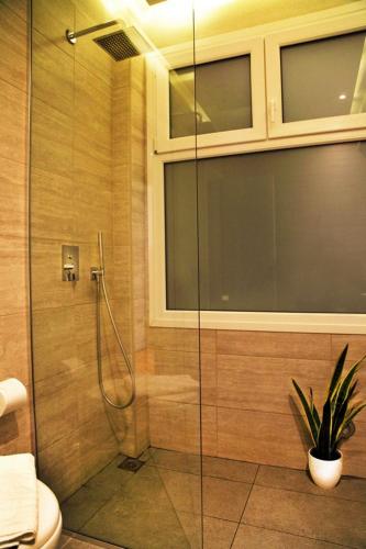 a shower with a glass door in a bathroom at My Athens House in Athens
