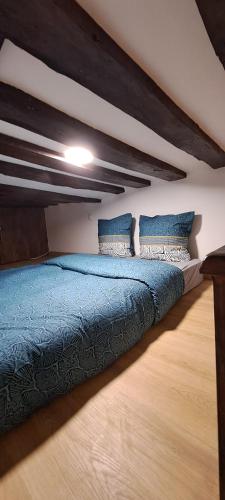 Elle comprend un grand lit avec des draps bleus et des oreillers bleus. dans l'établissement ÉCHAPPÉE Parisienne, à Paris