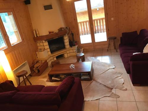 a living room with couches and a table and a fireplace at Family-friendly Self-catering Chalet Rental in Abondance - Sleeps 12 Portes du Soleil in Abondance