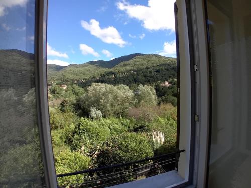a window with a view of trees and mountains at Ca' da Carmela in Savignone