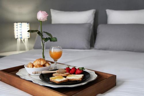 a tray with a plate of food on a bed at My Athens House in Athens