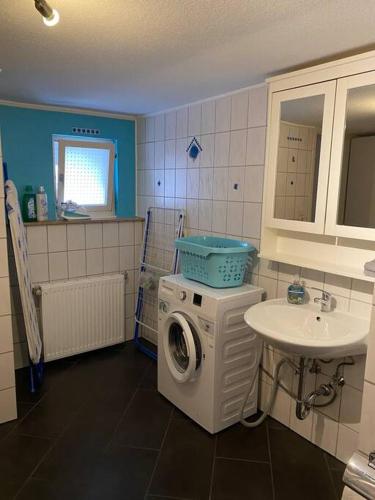 a bathroom with a washing machine and a sink at Maisonette Edna in Mechernich