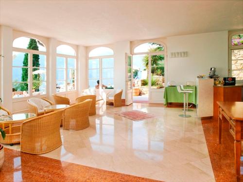a large living room with chairs and tables and windows at Bellevue San Lorenzo (Adults Only) in Malcesine