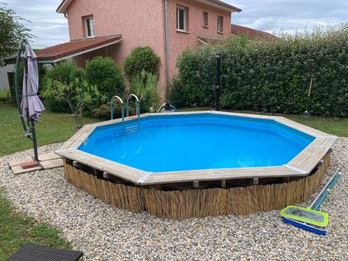 - une grande piscine dans une cour avec une maison dans l'établissement Vacances et travail, à Serrières-de-Briord