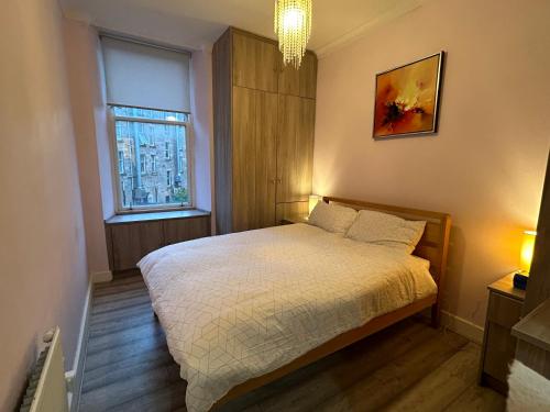 a small bedroom with a bed and a window at 2B apartment near Glasgow SEC, OVO Hydro & city centre in Glasgow