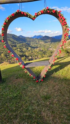 a heart shaped sign with a view of the mountains at Pousada do Sonho, PARTE ALTA in Visconde De Maua