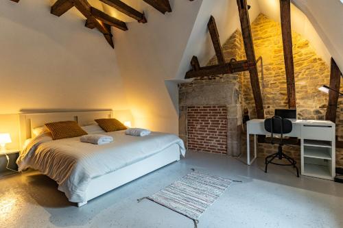 une chambre avec un lit et un mur de briques dans l'établissement Appart Cosy 6 Personnes - Parking Gratuit - Centre Ville Historique Dijon, à Dijon