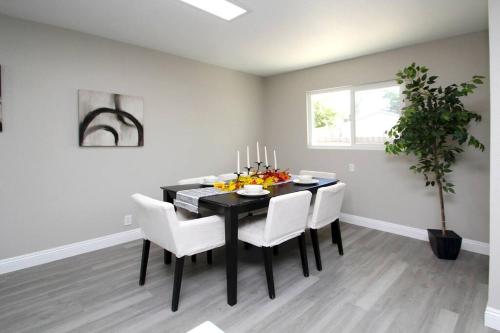 a dining room with a black table and white chairs at Entire House in Old Fig Garden in Fresno