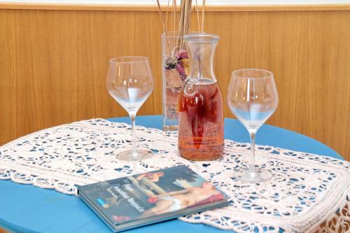 a table with two wine glasses and a book on it at Sonnino Suite in Rome