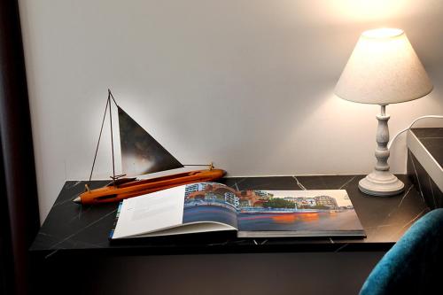 a book and a boat on a table with a lamp at My Athens House in Athens