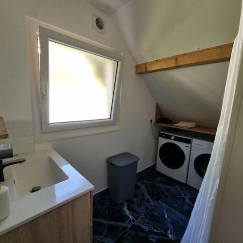 une petite cuisine avec un évier et une fenêtre dans l'établissement Appartement de la Villa du port, à Sévrier