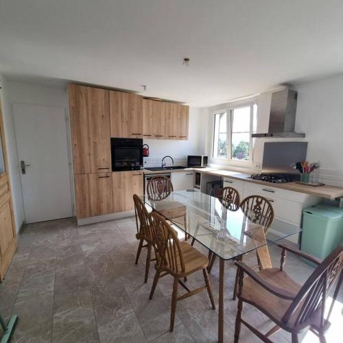 une cuisine avec une table en verre et des chaises. dans l'établissement Appartement de la Villa du port, à Sévrier