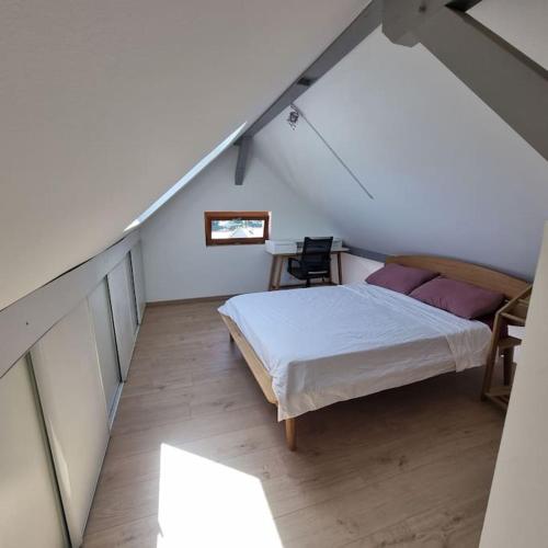 - une chambre mansardée avec un lit et une table dans l'établissement Appartement de la Villa du port, à Sévrier
