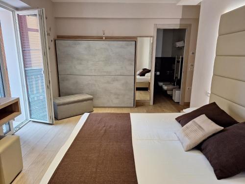 a bedroom with a white bed and a large window at Hotel Danieli La Castellana lago di Garda in Brenzone sul Garda