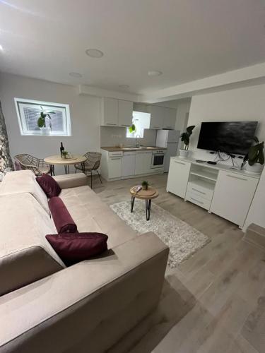 a living room with a large bed and a kitchen at Kolos Apartman 26 in Užice