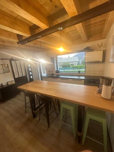 une grande table en bois dans une cuisine avec une grande fenêtre dans l'établissement Chalet Ohana, à Risoul