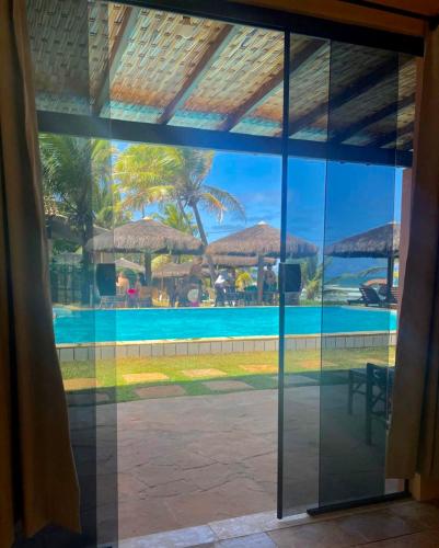 a view of a swimming pool through a window at Pousada Luar da Praia in Imbassai