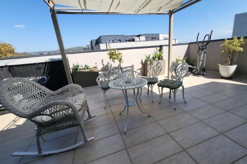 a patio with chairs and a table on a roof at SIBIU Bach Penthouse in Sibiu