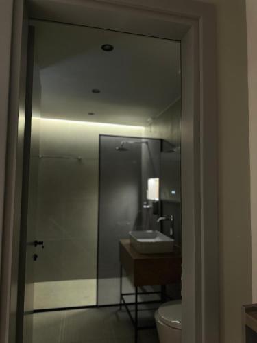 a bathroom with a sink and a toilet and a mirror at Hotel Liss in Lezhë