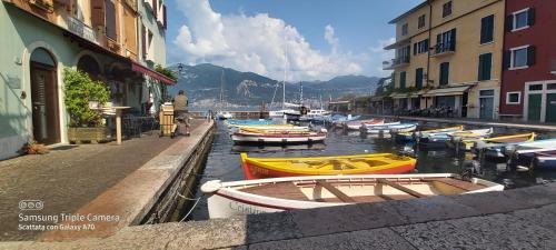 a group of boats docked in a canal with buildings at Hotel Danieli La Castellana lago di Garda in Brenzone sul Garda